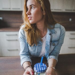 A young woman stands in the kitchen with a glass of milk
