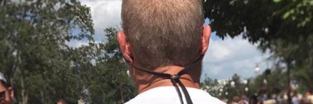 back of man's head walking through park