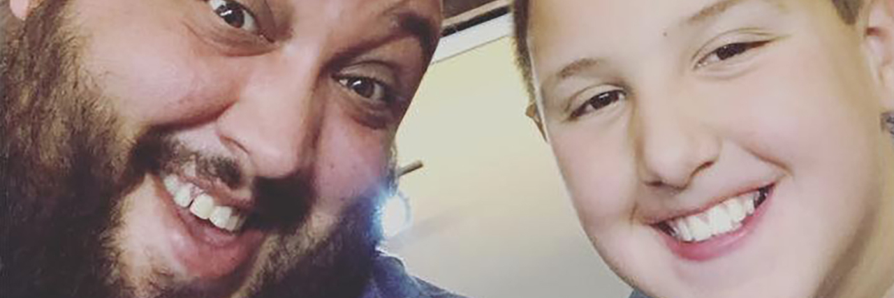 Teaching My Preadolescent Child About Mental Health and Mindfulness father and son smiling in front of picture for star wars battlefront 2