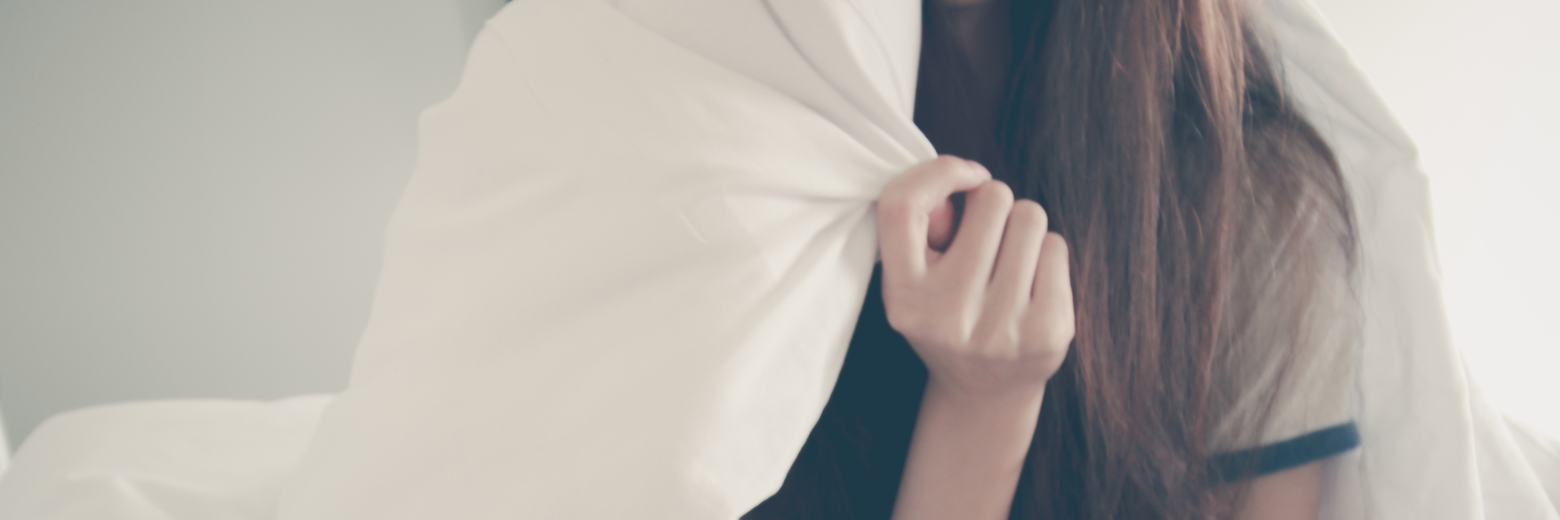 IBD: Being a Single Woman and Fighting Chronic Illness Alone woman lying alone in bed wrapped in her blanket