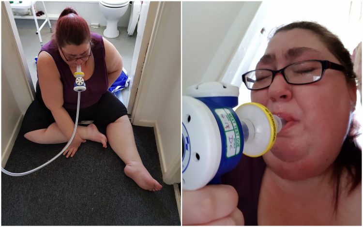 woman sitting on floor breathing through a tube device