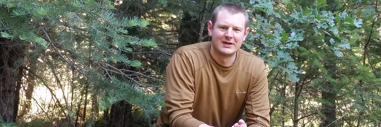 Using Realistic Hope to Manage Early-Onset Osteoarthritis man sitting on a log during a backpacking trip