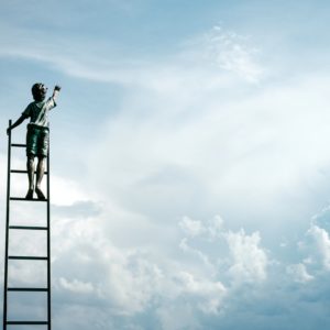 a child on a ladder reaching into the clouds