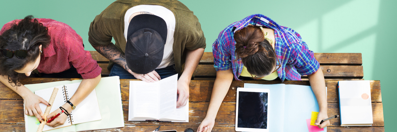 A Back-to-School Guide for Students With Mental Illness students studying. Text says: 12 reminders for students going to college with a mental illness