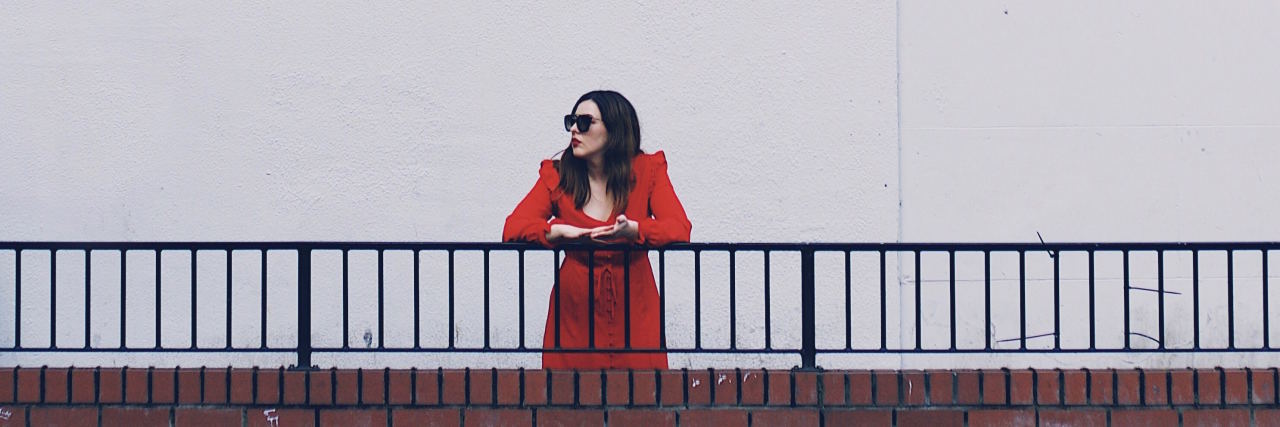 When You're Losing Friends to Your Mental Illness woman in red standing alone along railing