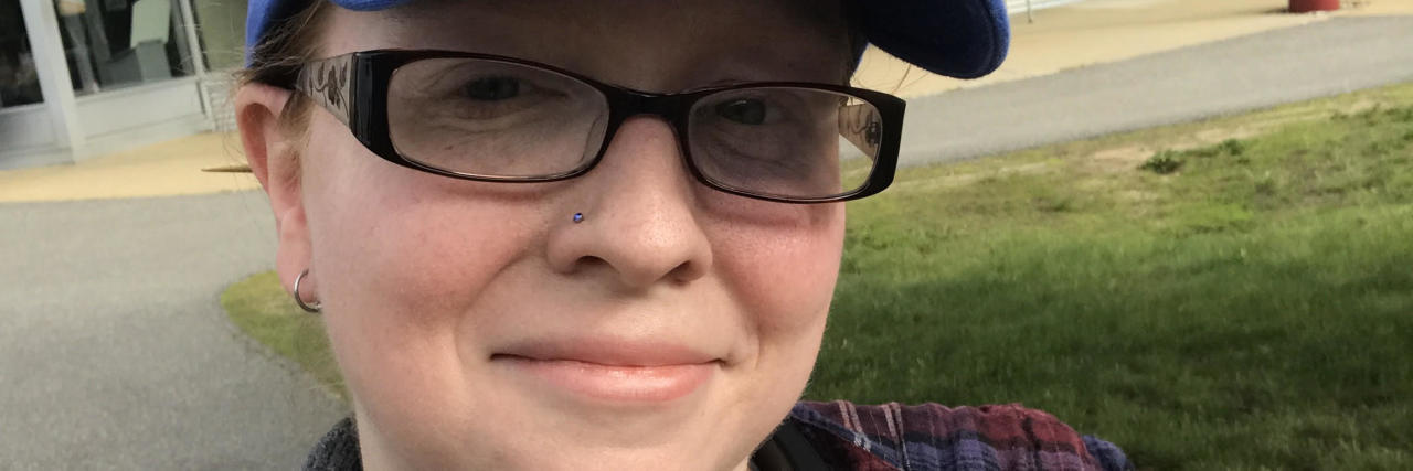 Ehlers-Danlos Syndrome: Constantly Worrying About Hurting Yourself woman wearing a baseball cap and giving a thumbs up
