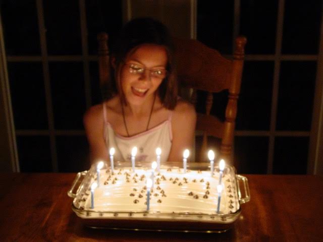 woman blowing out candles on birthday cake