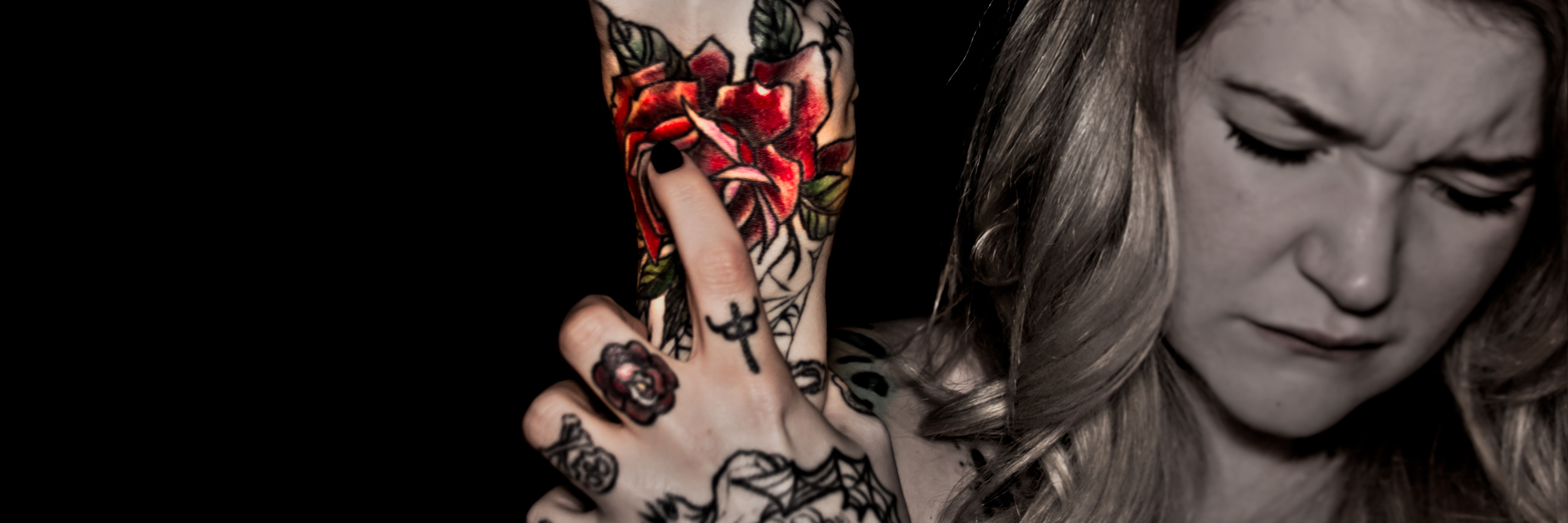 photo of woman with tattooes holding her wrist in pain