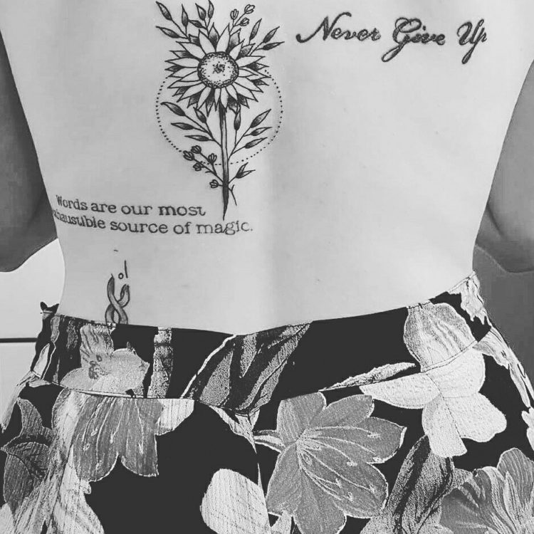 black and white tattoo of sunflower and words saying 'never give up'