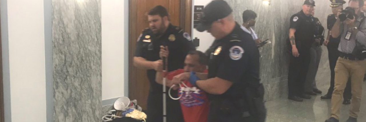 Disabled Protesters Removed From Graham-Cassidy Bill Hearing Blind man being arrested and dragged by police