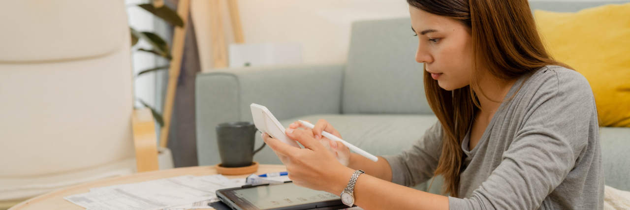 photo of a young woman at a small table researching college