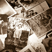 A pile of old black and white photographs.