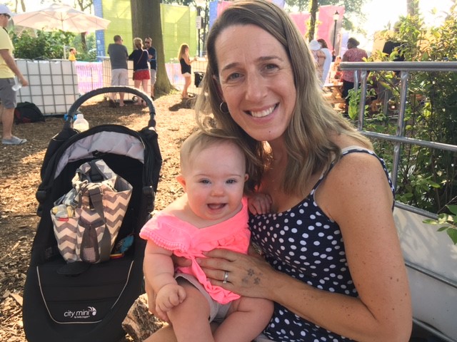 The author holding her daughter outdoors in a park