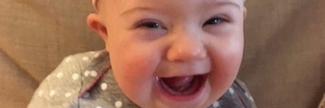 What One Year With My Daughter With Down Syndrome Has Taught Me The author's daughter, smiling, wearing a headband