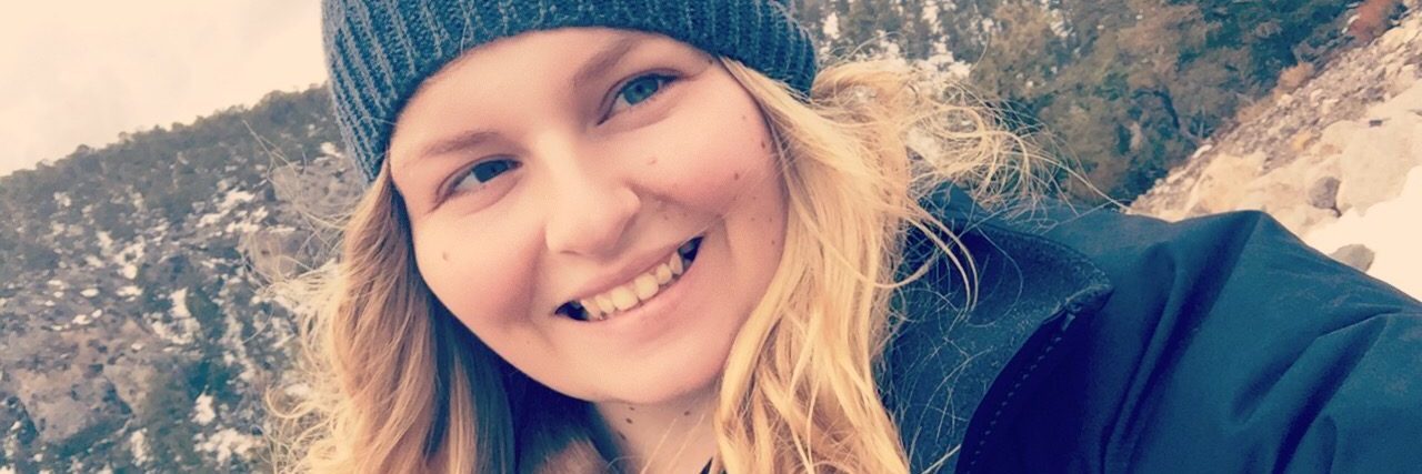 What a Photo of a Woman With Invisible Chronic Illness Can Reveal woman wearing a coat and beanie outside on a snowy day