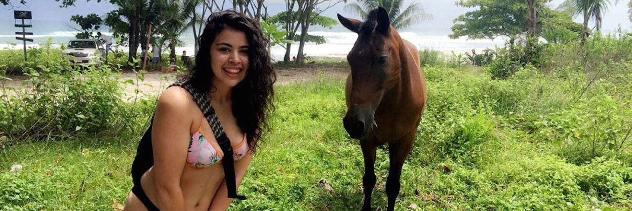 The writer standing near a horse.