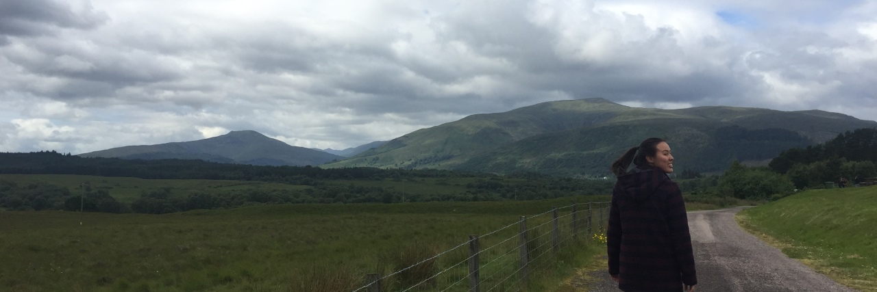 woman walking down a road in scotland