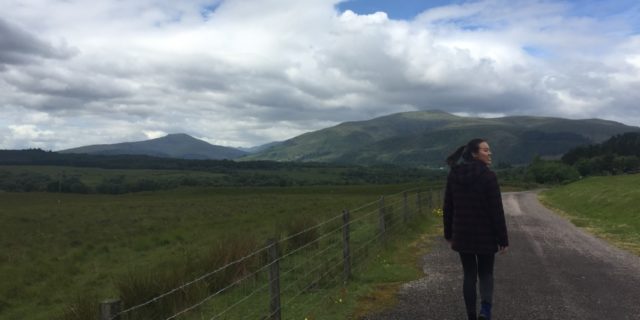 woman walking down a road in scotland