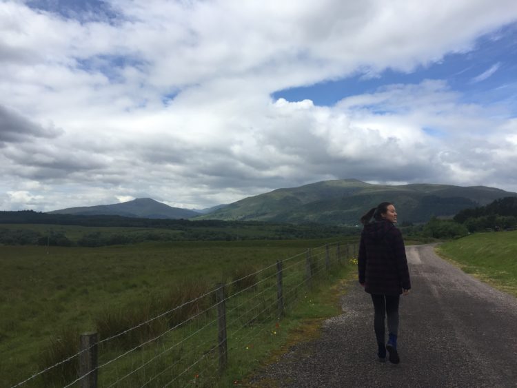 woman walking down a road in scotland