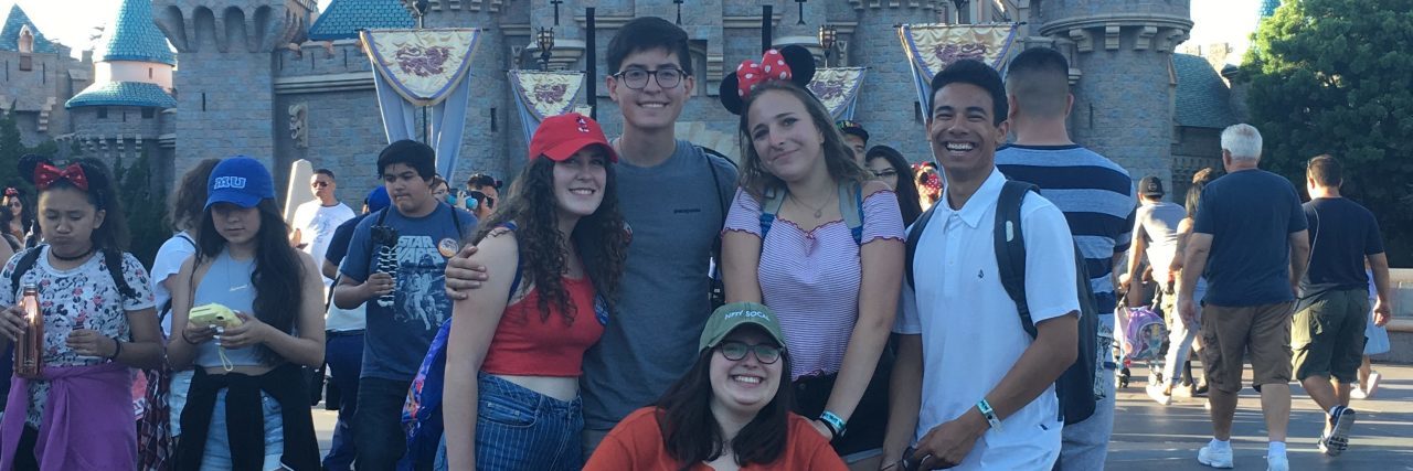 high school friends in front of disneyland castle