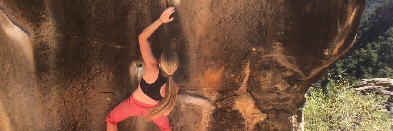5 Struggles of Having an Invisible Illness The writer rock climbing on a mountain.