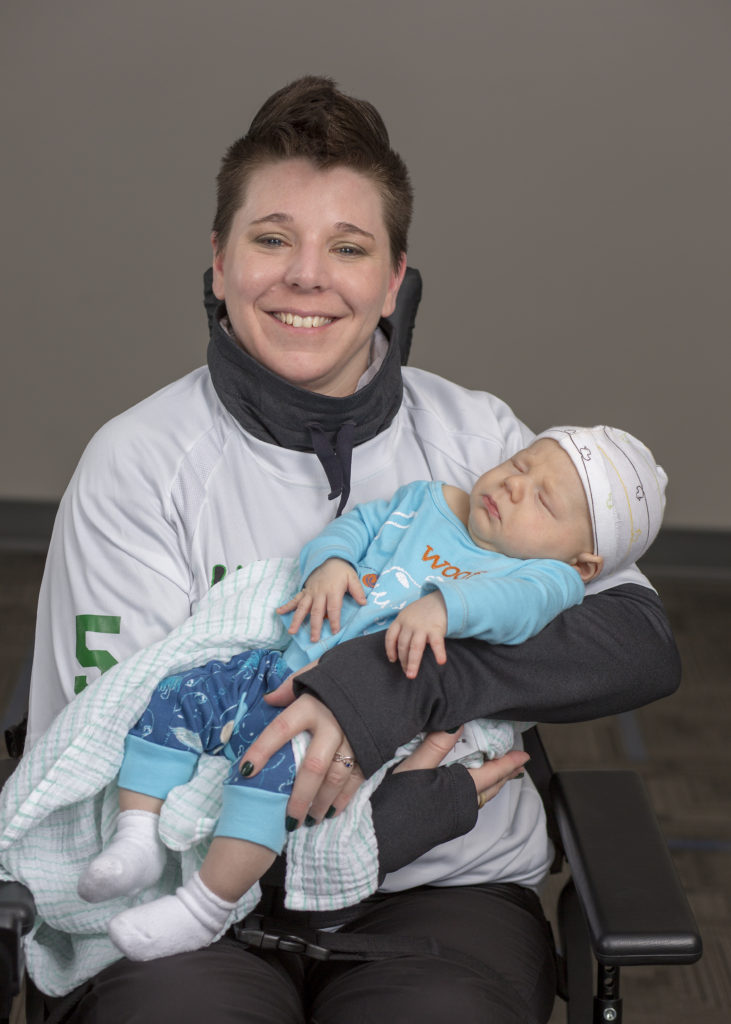 Me holding my newest nephew at his first power soccer tournament.