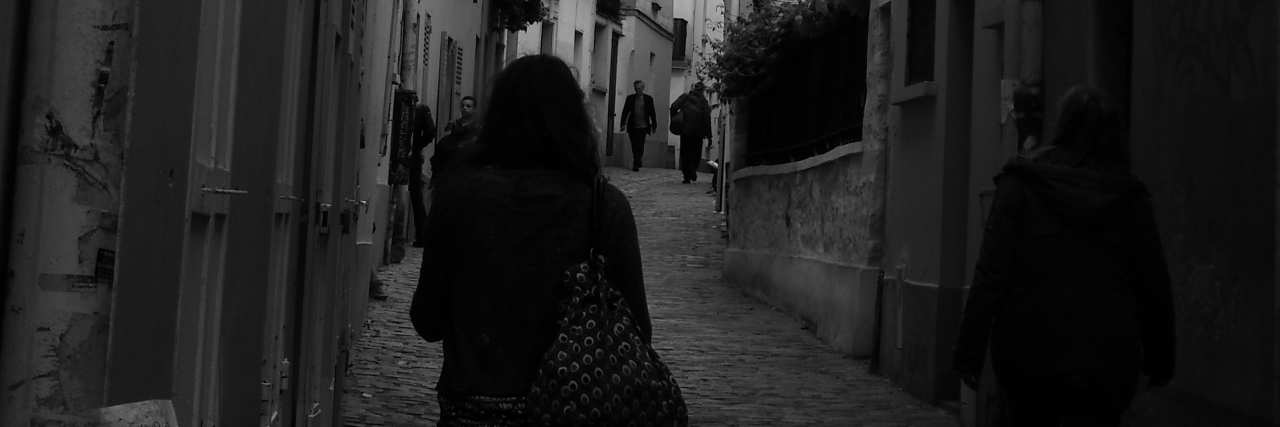 The writer walking down a city pathway.