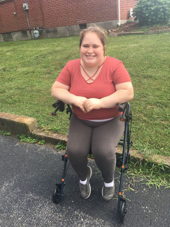 woman sitting on her four-wheel walker