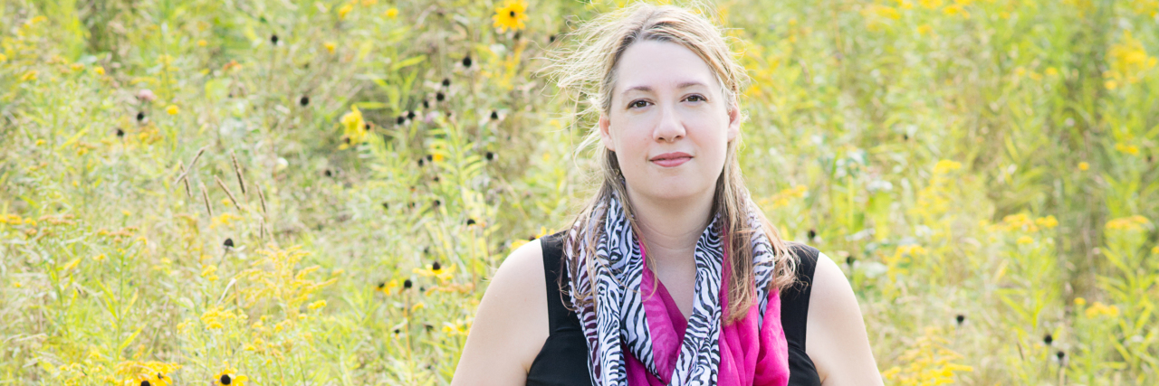 8 Basic Things Healthy People Take for Granted The writer standing in a field of flowers, with her wheelchair in front of her.