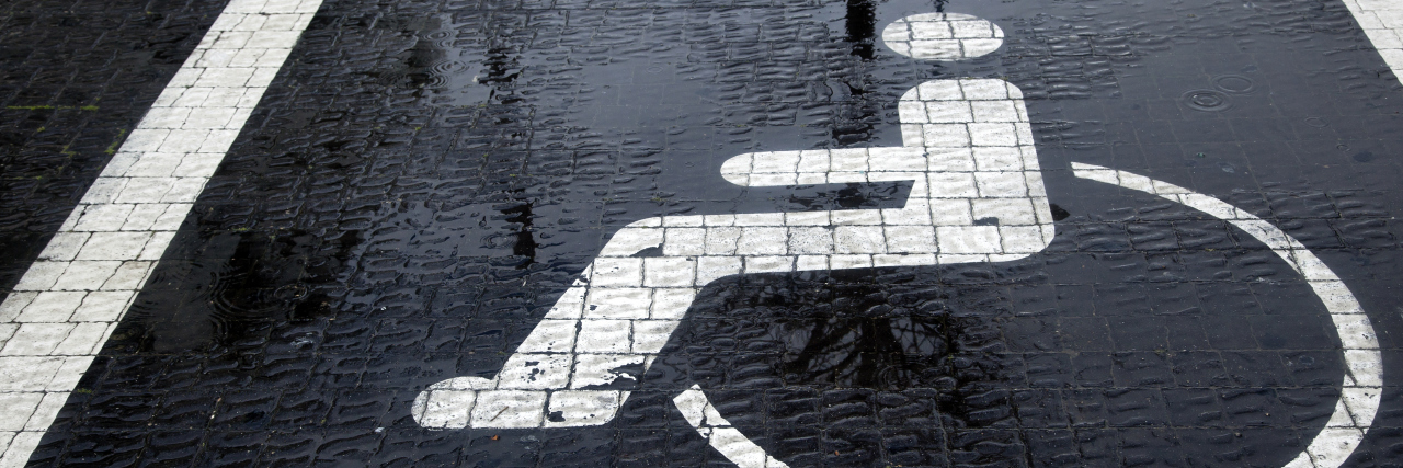 Judgmental Attitudes in the Disability Community Accessible parking space in the rain.