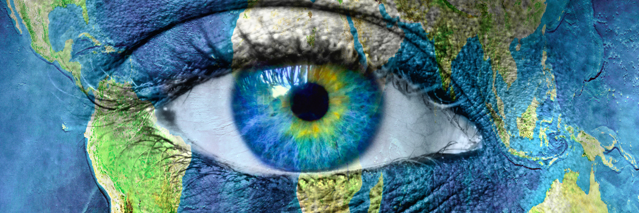 Why My Lupus Fatigue Is a Lot Like Never-Ending Jet Lag A woman's face painted with the globe, focusing close to her eye.
