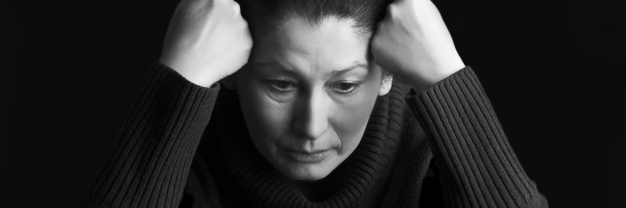 An older woman with a tired, sad expression.