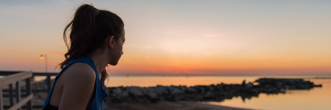 What to Know When You Feel Like Giving Up Because of Chronic Illness woman looking at the sunrise on a beach