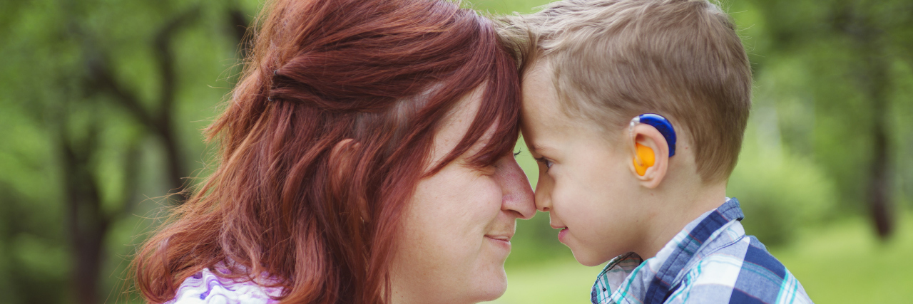To the Moms Who Raised Children With Disabilities Before the Internet Mother and son forehead to forehead, boy has a hearing aide