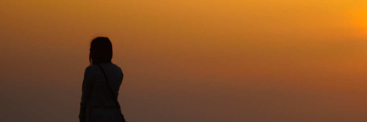 Grieving and Coping With Grief on Holidays and Significant Days Silhouette of woman in front of sunset sky
