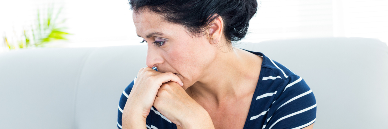 woman sitting on the couch looking worried