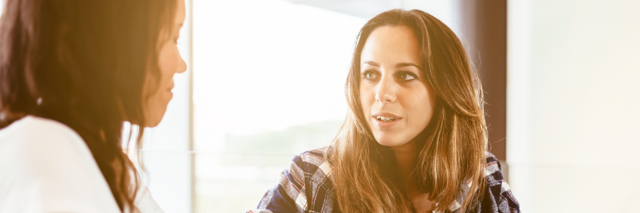 How I Curb My Anxiety Around New People two women talking at bar over drinks