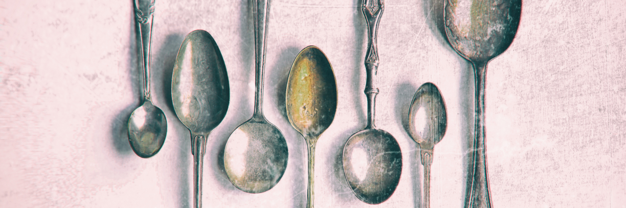 Antique silver spoons on white background.