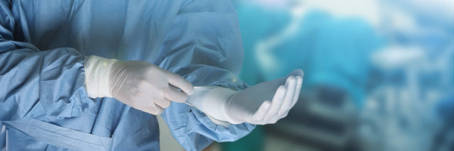 surgeon putting on gloves to prepare for surgery