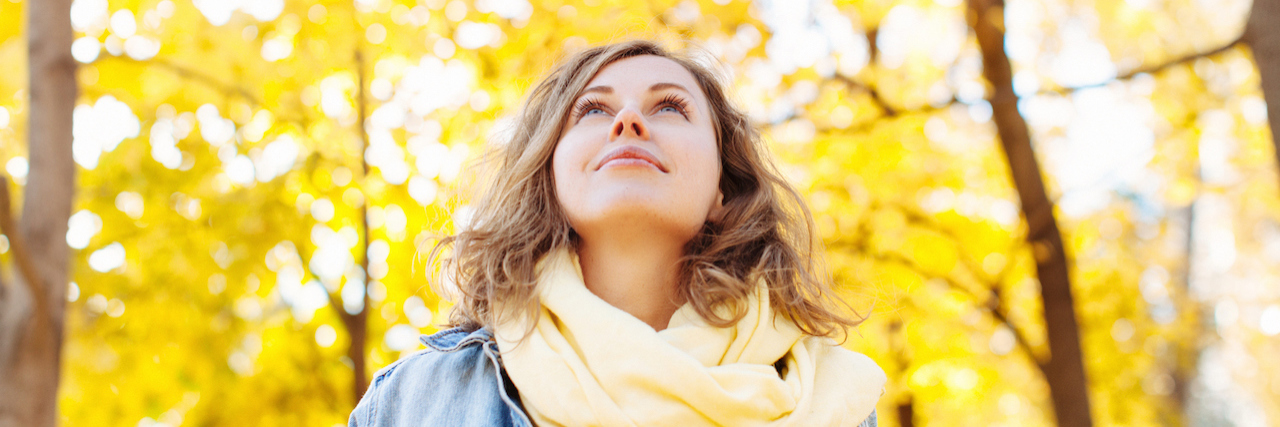 5 Things I Need You to Remember on World Suicide Prevention Day A woman looking up at trees on a fall day