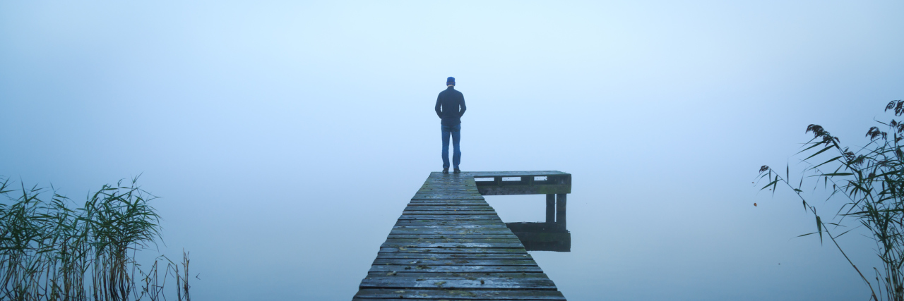 Don't Call Me Selfish Because I'm Suicidal man standing alone on jetty on lake on foggy day
