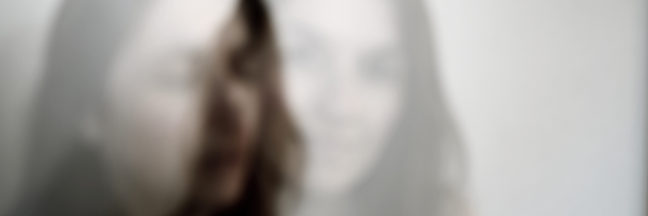 Out of focus multiple exposure portrait of a young Caucasian woman.