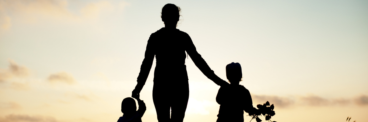The Reality of Hearing Your Child Say 'Mommy, Is My Brother a Ghost?' mother with her children at the seaside at sunset