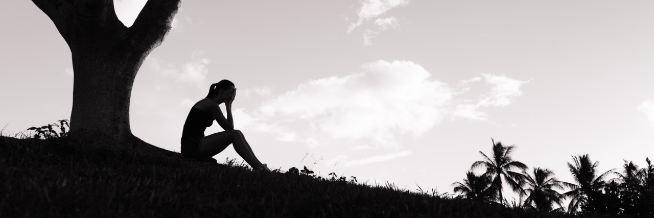 How to Cope With the Losses and Grief of Chronic Illness silhouette of woman sitting under a tree