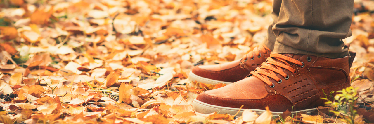 Being Happy About Arrival of Autumn as a Man With Multiple Sclerosis man standing outside on autumn leaves