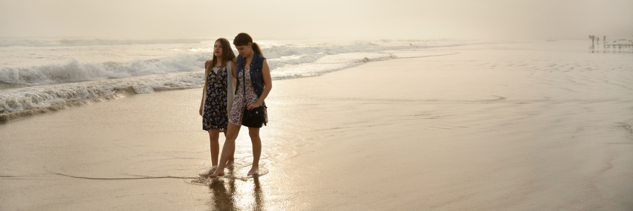 How to Help a Friend Who Is Feeling Suicidal two women walking on foggy beach together