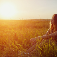 girl in a filed with the sun setting