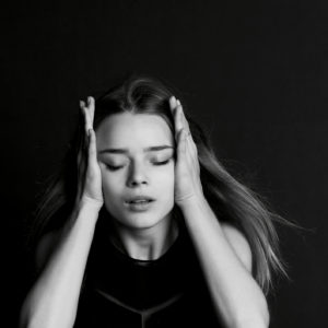 A woman holding her head.