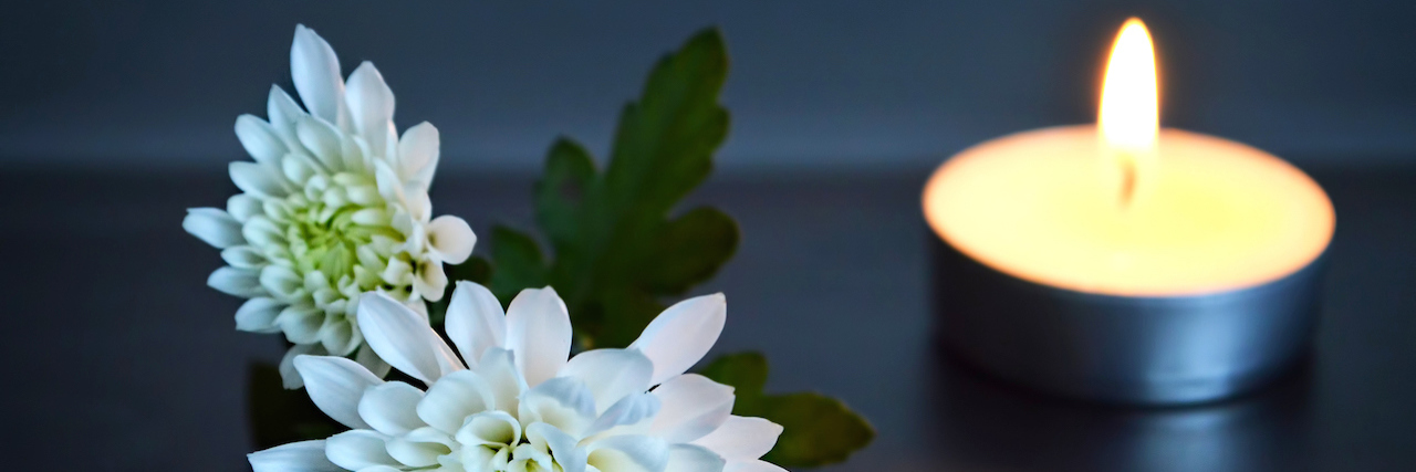 Sergei Neubauer's Obituary Shares Important Mental Health Message Flowers and a candle