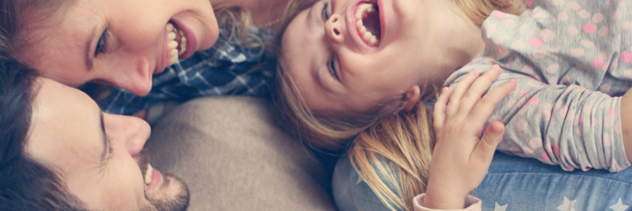 Sarcoidosis: Having a Supportive Family When Living With Illness family of four sitting on the couch and laughing